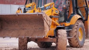 İnşaat alanında modern traktör. Büyük sarı traktör. Profesyonel inşaat malzemeleri. İnşaat alanında çalışma süreci