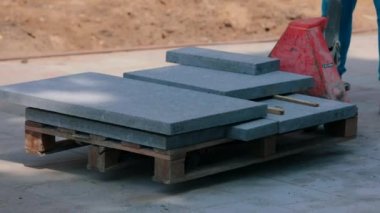 Granit fayanslar. Granit kiremitli palet. İnşaat alanında granit kiremitler
