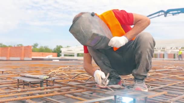 Soldador en una obra de construcción. Proceso de trabajo en una obra. Primer plano del soldador. Estructuras metálicas — Vídeos de Stock