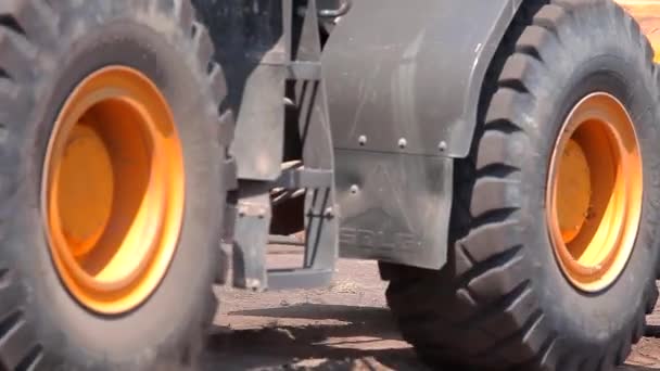 발굴자가 바퀴를 닫습니다. 거대 한 노란색 굴착기 가건축 현장에서 운전하고 있다. — 비디오
