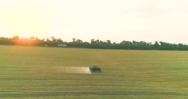İnsansız hava aracının buğday görüntüsüyle tarlayı ilaçlamak. Bir traktör buğdaya ot ilacı püskürtür. Traktör buğday tarlalarını ilaçlıyor..