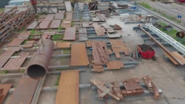 Büyük metal bir boru bir vinç tarafından kaldırılır. Metal yapılar montajı için atölyenin üzerinden uçuyor. Endüstriyel dış görünüş. Üst görünümü yerleştir