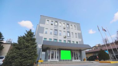 Yeşil ekranlı ofis binası. Reklam pankartı yeşil ekranda. Reklamlarınızı eklemek için yeşil ekranlı bir ofis binası..
