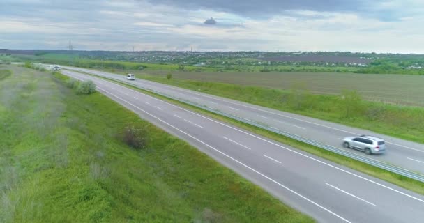 車は高速道路を走る。近代的な高速道路の空中ビュー。新しい近代的な道路上のビュー。高速道路を飛んで — ストック動画