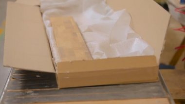 Bitmiş malların bir kutuda paketlenmesi. İşçiler bitmiş ürünleri bir kutuya doldururlar