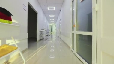 Kamera hastanenin boş koridoru boyunca döner. Modern bir hastanenin koridorları. Kliniğin boş, parlak koridoru. Modern bir kliniğin içinde.