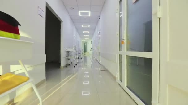 La caméra tourne le long du couloir vide de l'hôpital. Couloirs d'un hôpital moderne. Le couloir vide et lumineux de la clinique. Intérieur d'une clinique moderne — Video