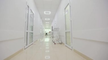 Modern bir kliniğin içinde. Kliniğin boş, parlak koridoru. Modern bir hastanenin koridorları. Kamera hastanenin boş koridoru boyunca dönüyor..