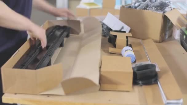 Packaging of finished goods in a box timelapse. Workers pack finished products into a box — Stockvideo