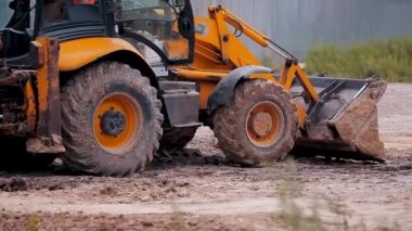 İnşaat alanında sarı traktör. İnşaat alanında çalışma süreci. Profesyonel inşaat ekipmanları.