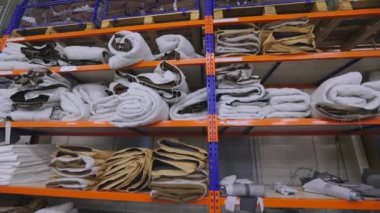 Kumaş fabrikasında tekstil deposu. Kumaş fabrikasında bir kumaş deposu. Tekstil fabrikasında kumaşlı raflar.