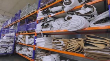Kumaş fabrikasında tekstil deposu. Bir giyim fabrikasında malzeme deposu. Bir tekstil fabrikasında malzeme dolu raflar
