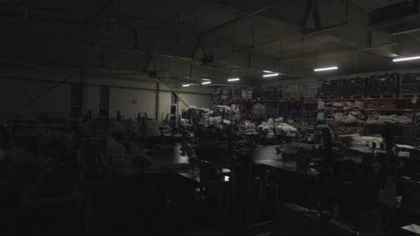 Het begin van de werkdag in een kledingfabriek. Het licht aandoen in de werkplaats van een kledingfabriek. Frame om video te starten — Stockvideo