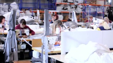 Tekstil fabrikasında çalışma süreci. Kadınlar dikiş atölyesinde çalışıyor. Modern tekstil fabrikası