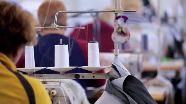 Veel naaisters werken in een kledingfabriek. Werkproces in een kledingfabriek. Grote naaiatelier. Naaisters maken producten in een fabriek. Kleding fabriek — Stockvideo