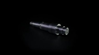 Metal cıvata siyah bir zeminde döner. Siyah arka planda yakın plan sürgüsü. Siyah arkaplanda sürgü