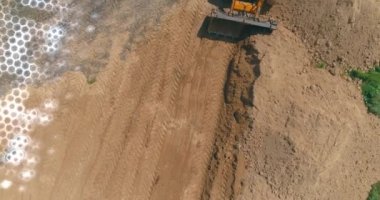 Buldozer, ilerisi için zemin katını dümdüz ediyor. Buldozer düz olmayan zemin örtüsünü kaldırıyor. Geleceğin inşaat alanının görselleştirilmesi