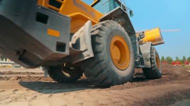 İnşaat alanında sarı traktör. Profesyonel inşaat malzemeleri. İnşaat alanında çalışma süreci