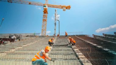 Güçlendirilmiş beton. İşçiler hızlandırılmış beton yapı yapıyorlar. Metal bir yapı için beton dökülüyor.
