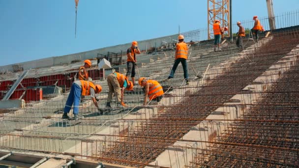 Arbetsprocess på en byggarbetsplats. Arbetarna skapar en förstärkt betongstruktur. Förstärkt betong. Hällande betong till en metallstruktur. — Stockvideo
