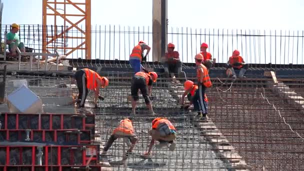 Construção de edifícios. Processo de trabalho num estaleiro. Construtores fazem uma estrutura de concreto armado — Vídeo de Stock