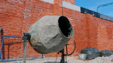 İnşaat alanında beton karıştırıcı. Ev inşaatında beton karıştırıcı. İnşaat alanında dönen beton karıştırıcı