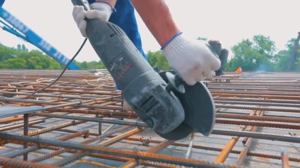A man works with a circular saw. Construction worker cuts rebar with circular saw — Stock video