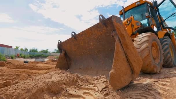 The tractor works at a construction site. Working process at a construction site. Tractor bucket close up — Stock video