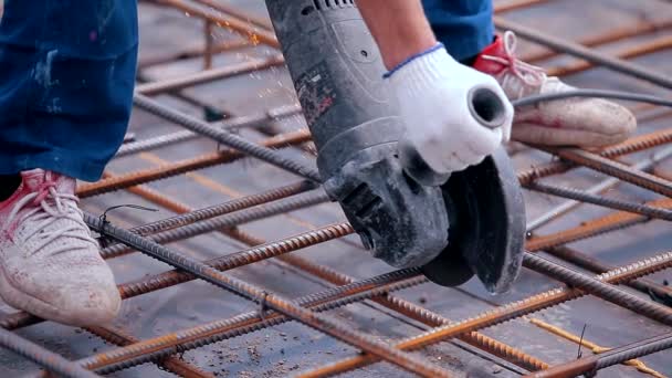 A construction worker cuts reinforcement with a circular saw. Circular saw close-up. A man works with a circular saw. — Stockvideo