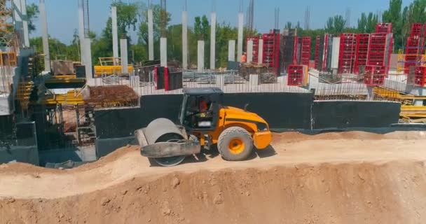 El compactador de suelos alinea la tierra en un sitio de construcción. Compactador de suelo compacta el suelo en una obra de construcción — Vídeos de Stock