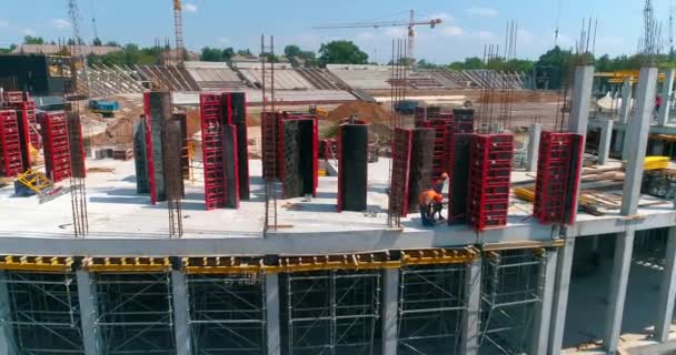 İnşaatçılar yeni bir stadyumun şantiyesinde resmi işler yapıyorlar. Modern bir futbol stadyumunun yapım süreci. Güçlendirilmiş beton yapının havadan görüntüsü — Stok video