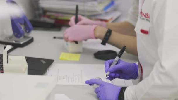 Trabajadores del laboratorio en el laboratorio. El médico del hospital toma notas. Proceso de trabajo en un moderno laboratorio médico — Vídeos de Stock