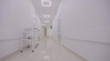 Modern bir kliniğin içinde. Kliniğin boş, parlak koridoru. Modern bir hastanenin koridorları. Kamera hastanenin boş koridoru boyunca dönüyor..