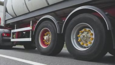 Kamyonlar yol boyunca gidiyor. Tank kamyonu olan bir kamyon otoyol boyunca yaklaşır. Tehlikeli malların nakliyesi