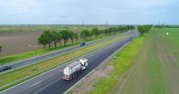 Przejażdżki ciężarówką po nowoczesnej autostradzie wokół zielonej trawy widok z góry. Ciężarówka na autostradzie widok z drona. — Wideo stockowe