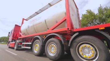 Kamyonlar yol boyunca gidiyor. Tank kamyonu olan bir kamyon otoyol boyunca yaklaşır. Tehlikeli malların nakliyesi