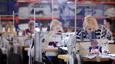 Tekstil fabrikasında çalışma süreci. Kadınlar dikiş atölyesinde çalışıyor. Modern tekstil fabrikası