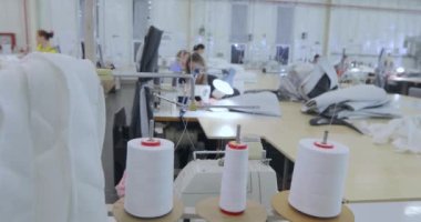 Yakın plan bir iplik izi. Dikiş fabrikasında iplik makaraları. Dikiş fabrikasında dikiş malzemeleri..