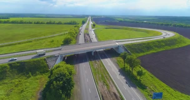 Transportutbyte på motorvägen. Stor väg med bilar ovanifrån i bra väder. Bilar kör längs motorvägen utanför staden — Stockvideo