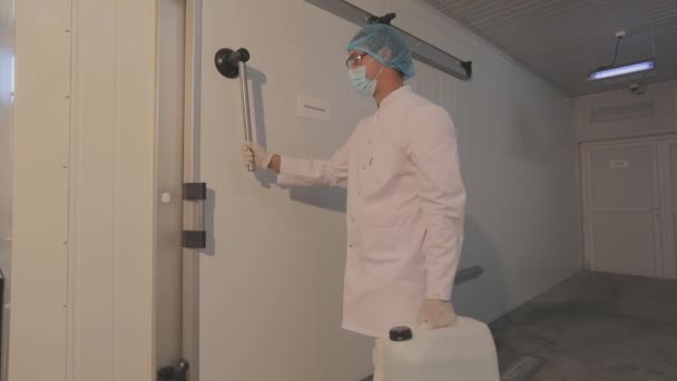 A worker in a modern production facility. Worker with mucin bottle. White, clean production area. — стоковое видео