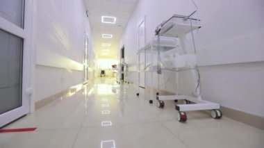Kliniğin boş, parlak koridoru. Modern bir kliniğin içinde. Modern bir hastanenin koridorları. Kamera hastanenin boş koridoru boyunca dönüyor..