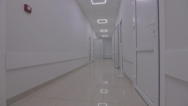 Коридоры современной больницы. Камера проходит по пустому коридору больницы. Пустой, светлый коридор клиники. Интерьер современной клиники — стоковое видео