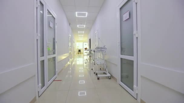 The camera zooms in on an empty wheelchair for the disabled. Wheelchair in the clinic corridor. A frame that simulates the loss. Interior of a modern clinic — Stock video