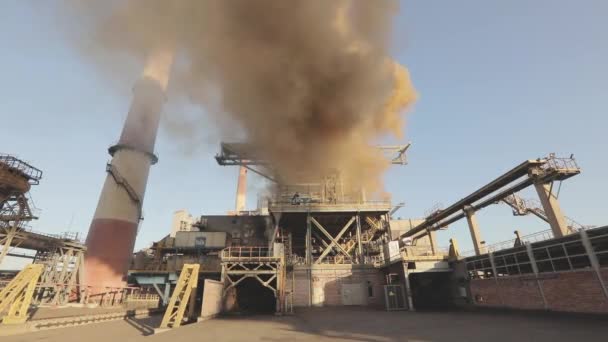 Thick brown smoke from the chimney of the plant. Exterior of a large metallurgical plant. Emission of white smoke from the chimney of the plant. Harm to the environment. — Stockvideo