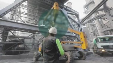 İşçi fabrikanın içinden geçer. Fabrikada güçlendirilmiş gerçeklik görselleştirme. Bir mühendis inşaat malzemelerinin yanından geçiyor.