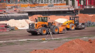 İnşaat alanında sarı traktör. İnşaat alanında çalışma süreci. Profesyonel inşaat ekipmanları.