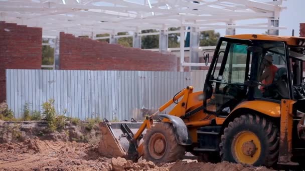 Yellow tractor on a construction site. Work process at a construction site. Professional construction equipment. — 图库视频影像