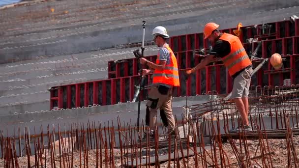 Nalévání betonu do kovové konstrukce. Pracovníci tvoří železobetonovou konstrukci. Zesílený beton. Pracovní proces na staveništi — Stock video