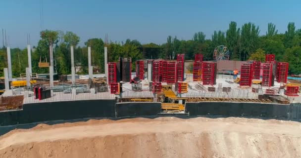 I costruttori realizzano casseforme nel cantiere di un nuovo stadio. Processo di costruzione di un moderno stadio di calcio. Veduta aerea della costruzione in cemento armato — Video Stock