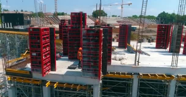 Bau eines modernen Fußballstadions. Bauarbeiter stellen Schalungen auf der Baustelle für ein neues Stadion her. Luftaufnahme der Stahlbetonkonstruktion — Stockvideo